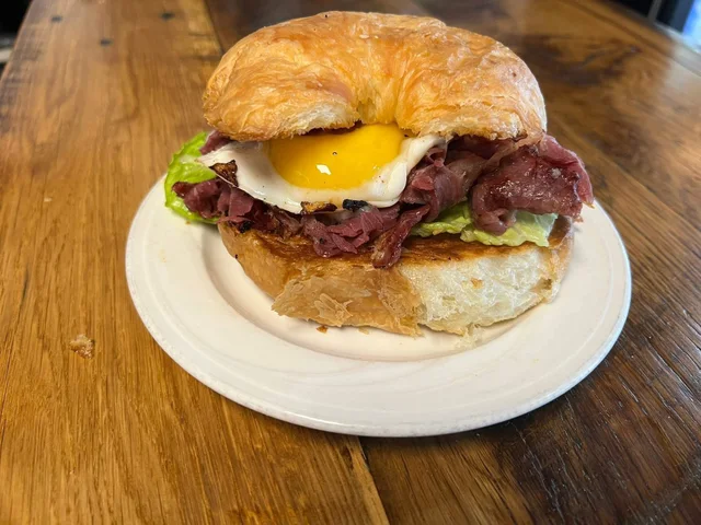 Pastrami and a fried egg on a croissant.