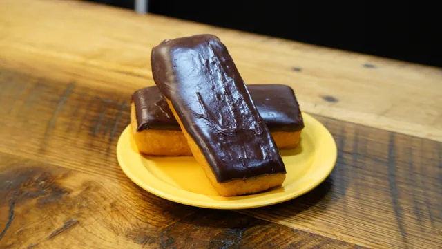 Two rectangular donuts with glossy chocolate icing on a yellow plate.
