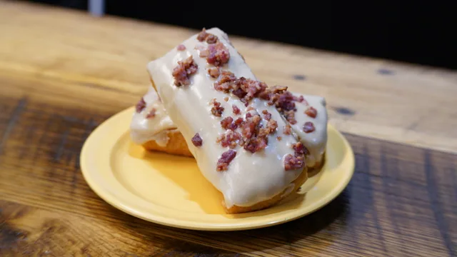 Two pale-iced rectangular donuts sprinkled with small reddish-brown topping pieces.