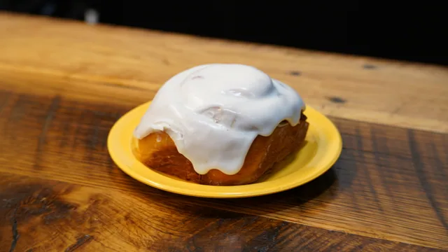 A tall round sweet roll covered with a thick layer of white icing.