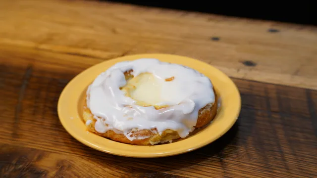 A round pastry with a pale yellow center and a white-iced edge.