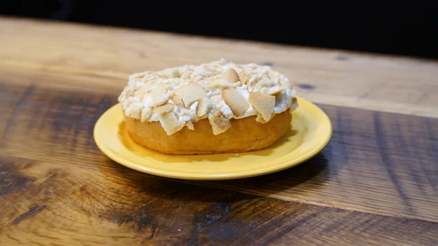 A round iced pastry generously covered with thin pale flakes.